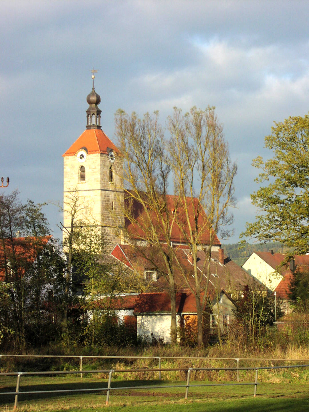 Pfarrkirche sonnenbeschienen vor kahlen Bäumen